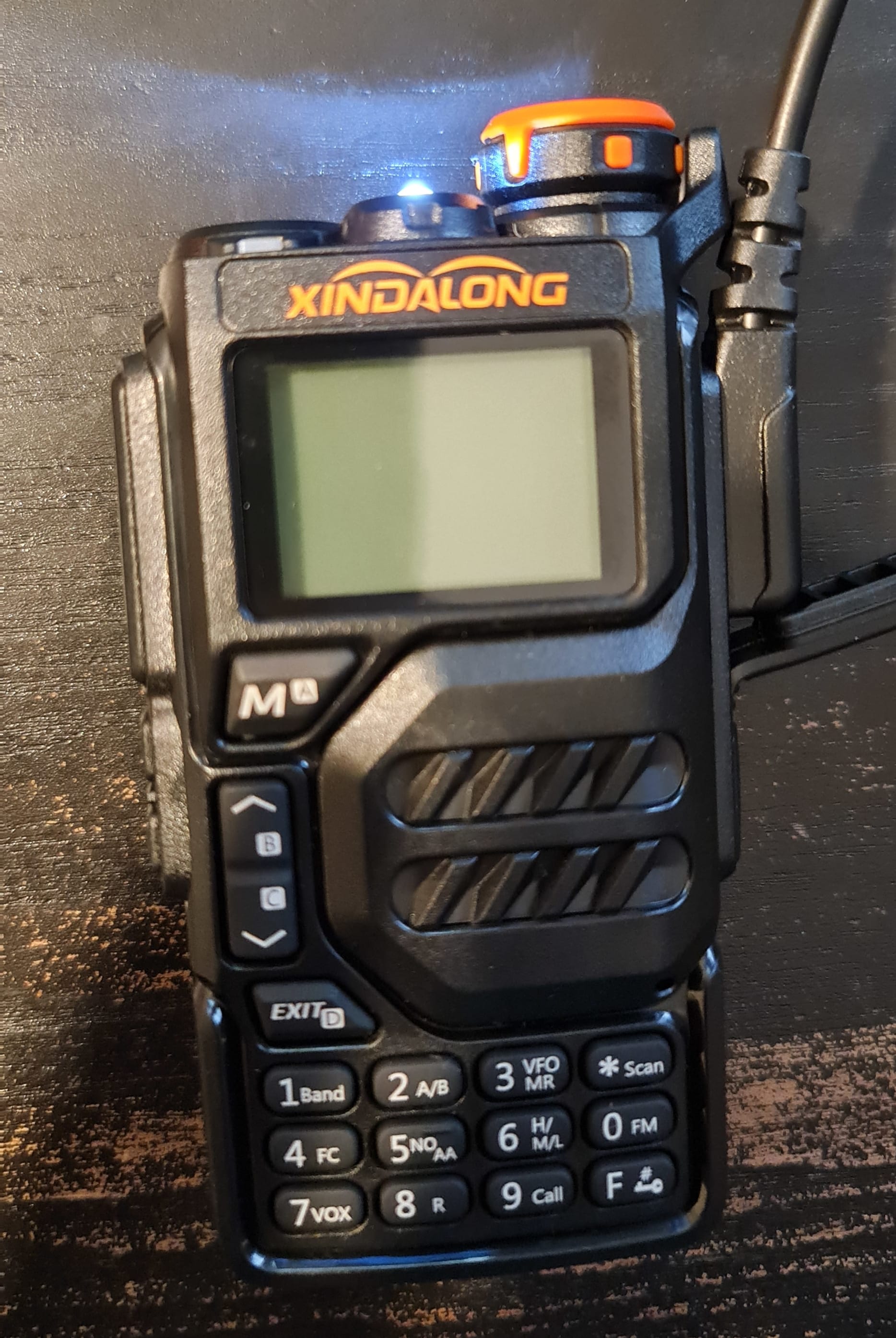 A black UV-K5 radio with its LED torch turned on and screen blank, indicating the device is in bootloader mode